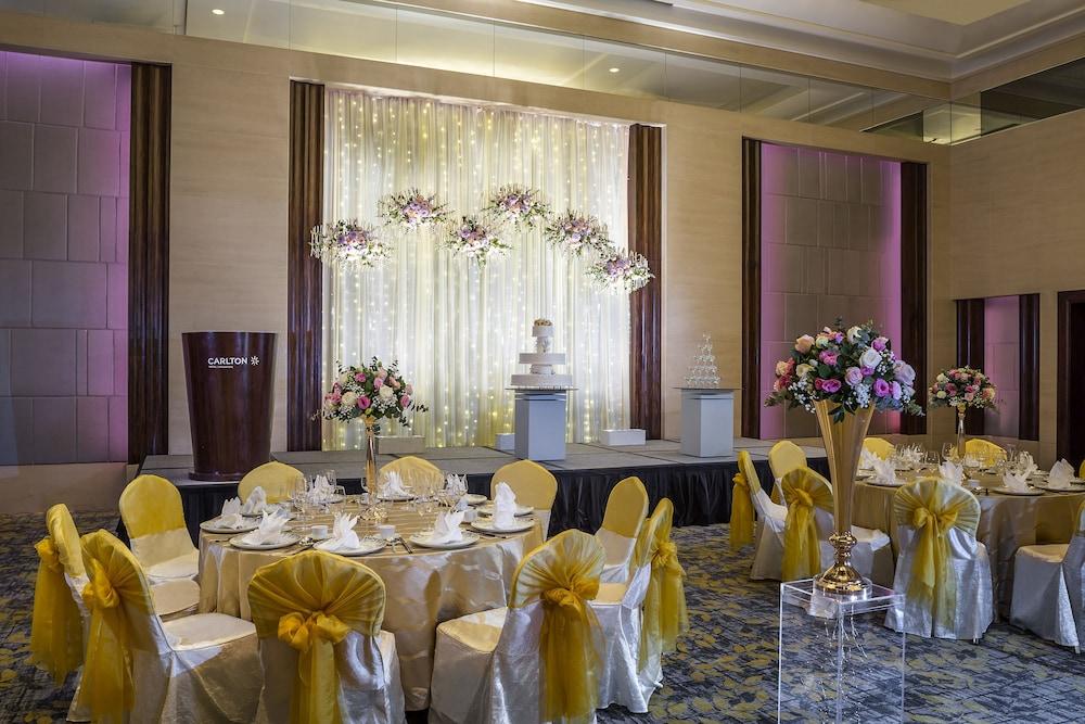 Carlton Hotel Singapore Esterno foto The photo shows a beautifully decorated banquet or event space. In the background, there is a shimmering curtain adorned with lights and floral arrangements. There are two elegant wedding cakes displayed on podiums beneath the flowers. The tables are