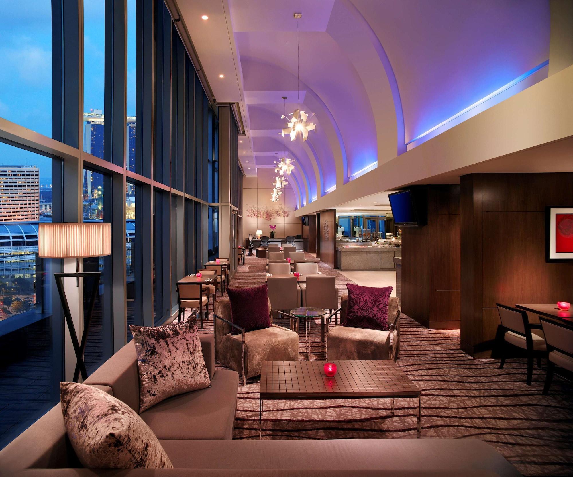 Carlton Hotel Singapore Esterno foto The photo depicts a stylish and modern lounge interior. It features large windows that allow ample natural light to filter in, enhancing the bright and airy atmosphere. The space is adorned with contemporary furniture, including comfortable seating w