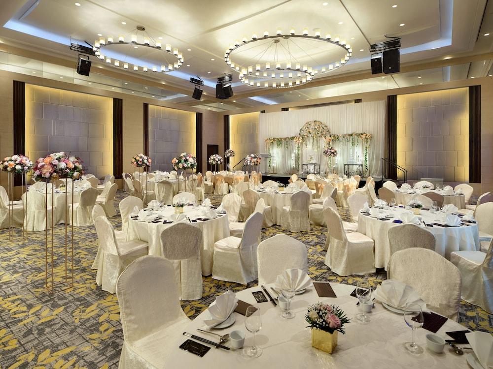 Carlton Hotel Singapore Esterno foto The photo shows an elegantly arranged banquet hall designed for events such as weddings or formal gatherings. The room features round tables, each covered with white tablecloths and adorned with decorative centerpieces. The chairs are also draped in 
