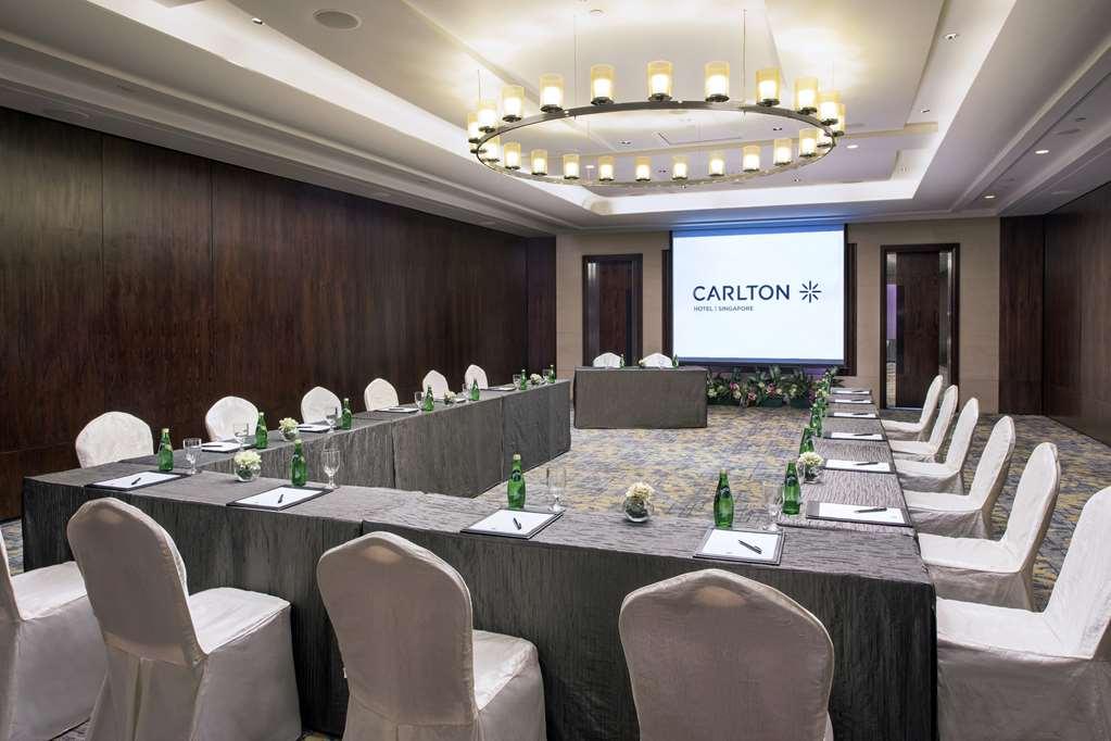Carlton Hotel Singapore Servizi foto The photo shows a conference room set up for a meeting or presentation. There is a large rectangular table in the center, with chairs surrounding it. The table is covered with a dark tablecloth, and there are small decorations or plants on it. Water 