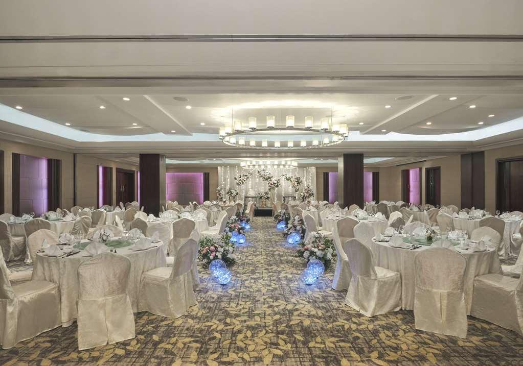Carlton Hotel Singapore Servizi foto The photo depicts an elegant event space set up for a formal gathering. The room features several round tables covered with white tablecloths and neatly arranged with dinnerware and decorations. Each table is surrounded by white chairs that have cove