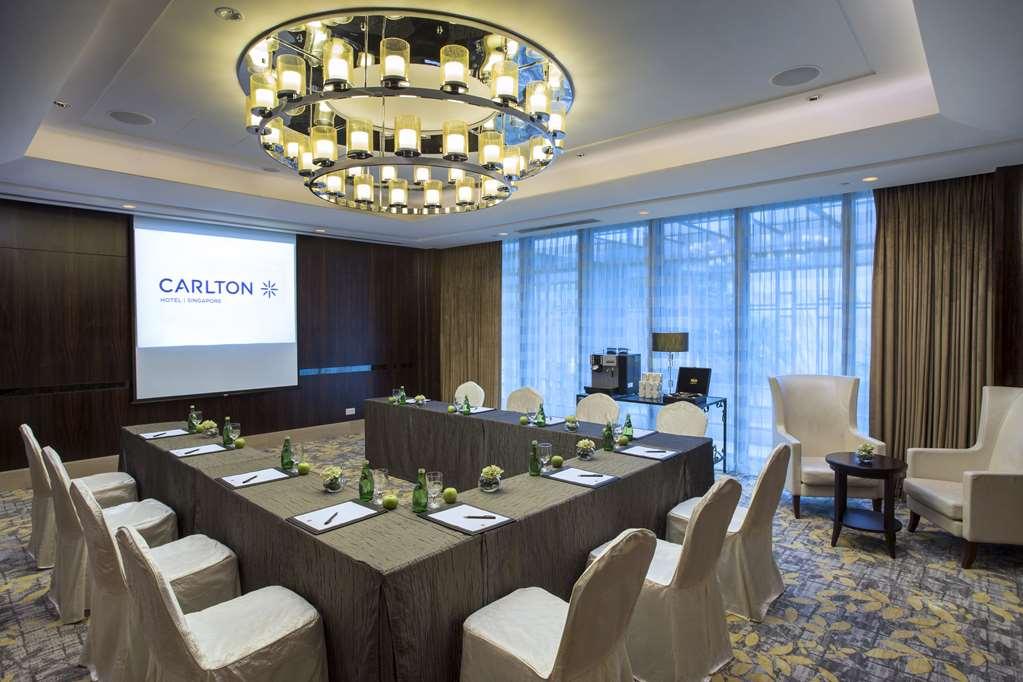Carlton Hotel Singapore Servizi foto The photo shows a well-decorated conference room. There is a large round chandelier hanging from the ceiling, illuminating the space. In the center, a long rectangular table is covered with a gray tablecloth, surrounded by several chairs. Each chair 