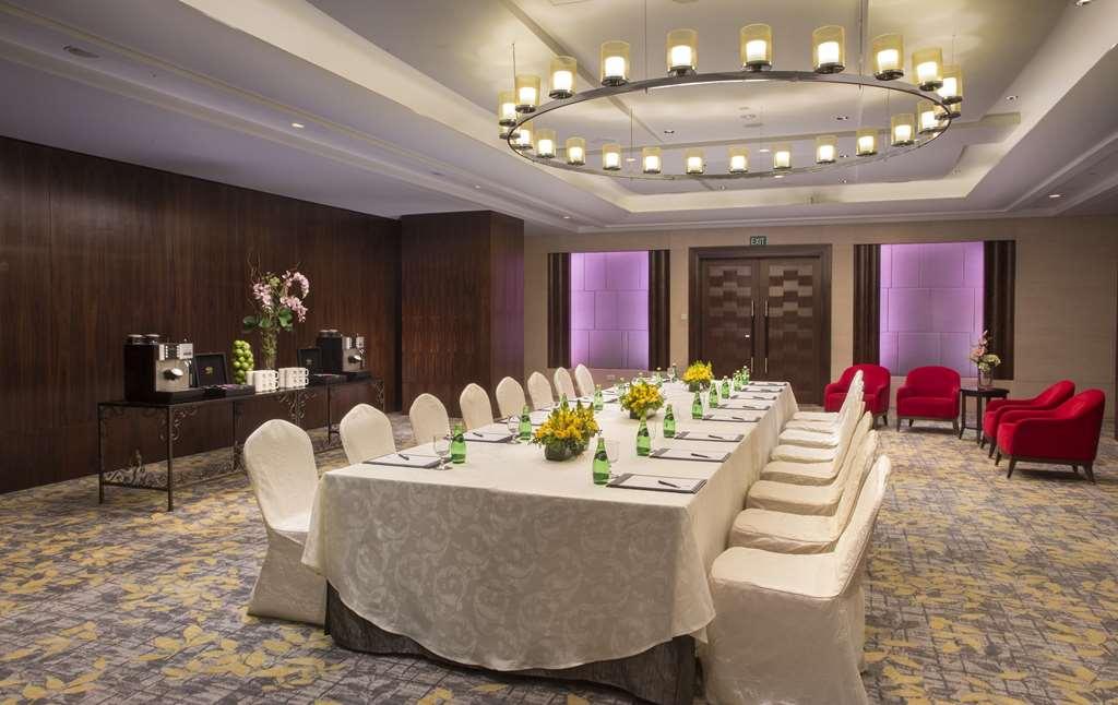Carlton Hotel Singapore Servizi foto The photo shows a well-decorated conference or meeting room. It features a long rectangular table covered with a white tablecloth, surrounded by chairs, some of which are draped in white fabric. There are several vases with flowers as centerpieces on
