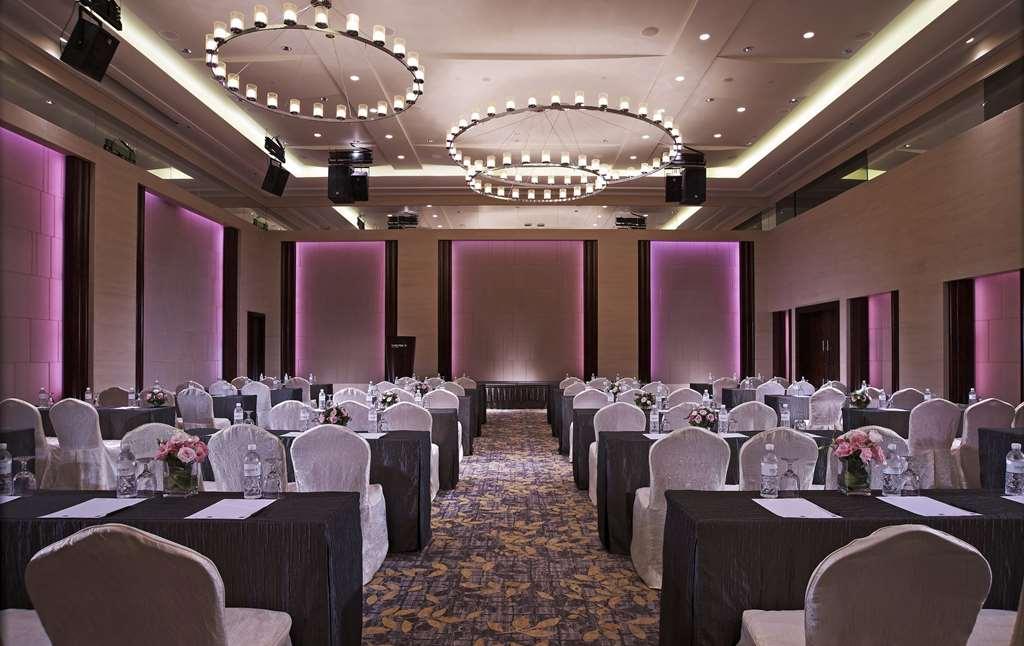 Carlton Hotel Singapore Servizi foto The photo shows an elegantly arranged conference or banquet room. It features rows of tables covered in black tablecloths, with light-colored chairs around them. Flowers and water bottles are placed on each table. The room is well-lit, with modern ci