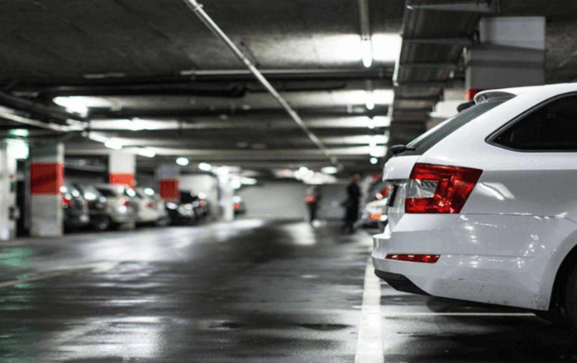Carlton Hotel Singapore Esterno foto The photo shows a parking garage with a focus on the rear of a white car parked in the foreground. The garage has a concrete ceiling and dim lighting, creating a somewhat industrial atmosphere. In the background, several other cars are visible, parke