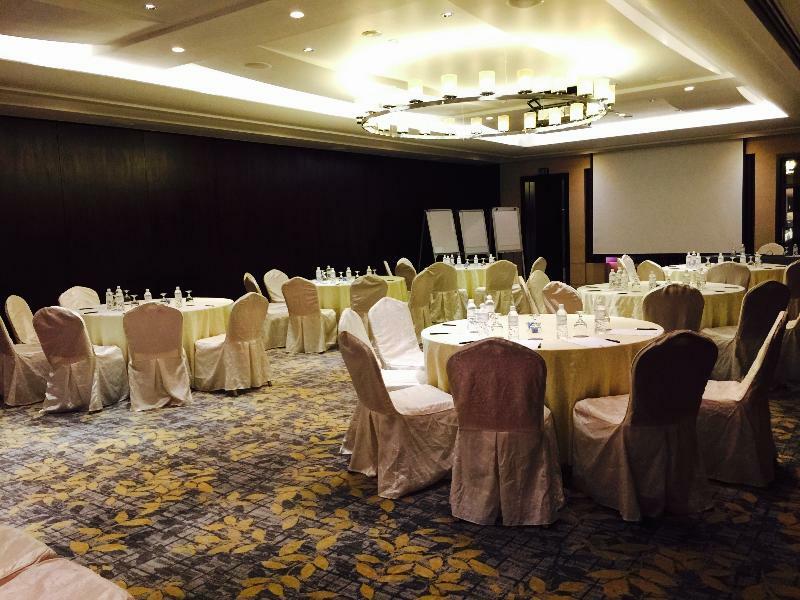 Carlton Hotel Singapore Esterno foto The photo depicts an elegantly arranged indoor event space. There are several round tables covered with light-colored tablecloths, each adorned with glassware and centerpieces. The chairs surrounding the tables are draped in white, adding to the room